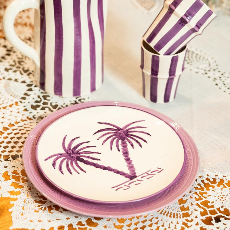 Assiettes en céramique motif palmier violet assorties aux plats rayés, décoration de table artisanale marocaine.